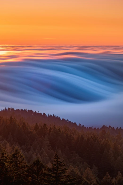 a sky view with clouds and trees near by