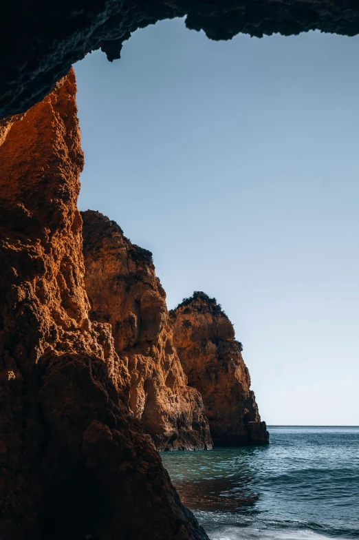 large rock formation at the edge of a body of water