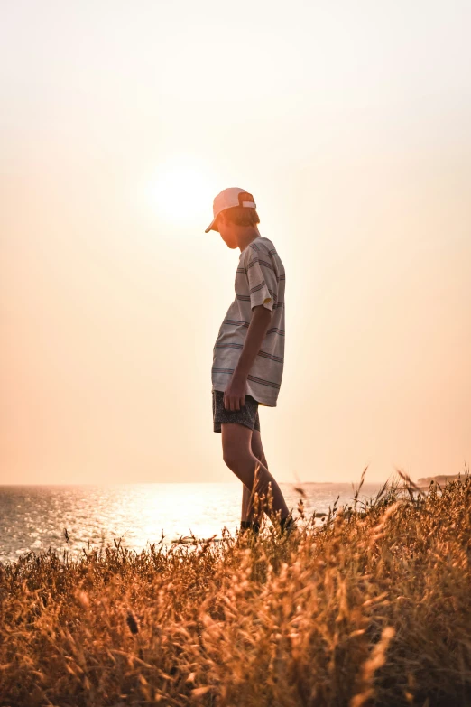 man walking near the beach at sunset