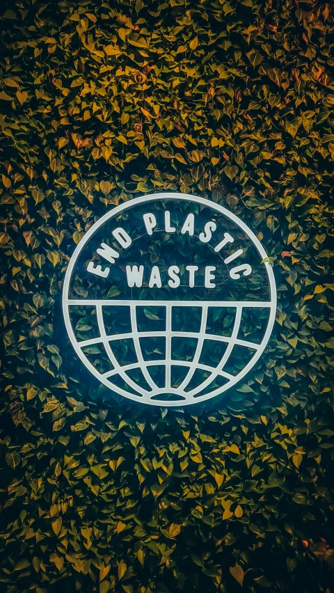 a large, circular plastic waste sign on top of some grass