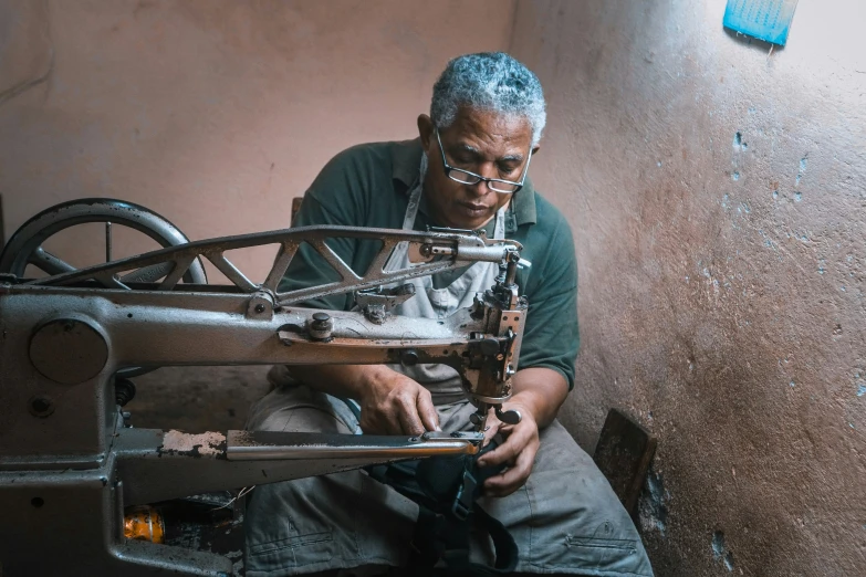 an old man is working on the sewing machine