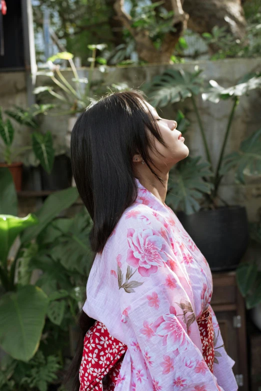 a woman in traditional japanese clothing looking up