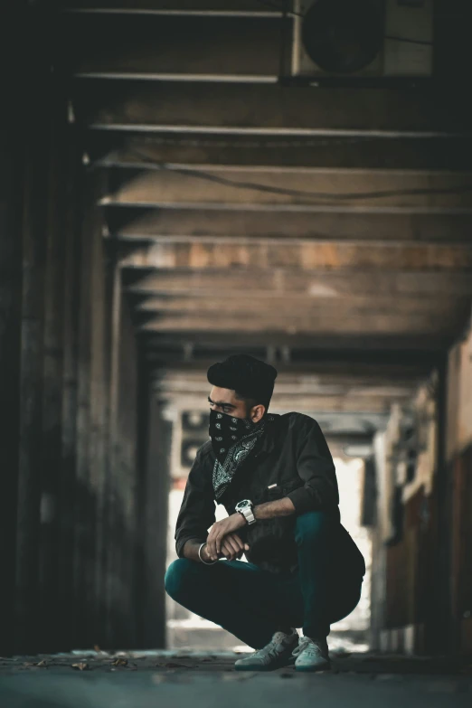 a man kneeling down with his hands in his pockets