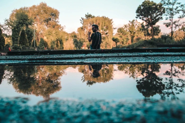 a man standing on top of a large lake in the woods