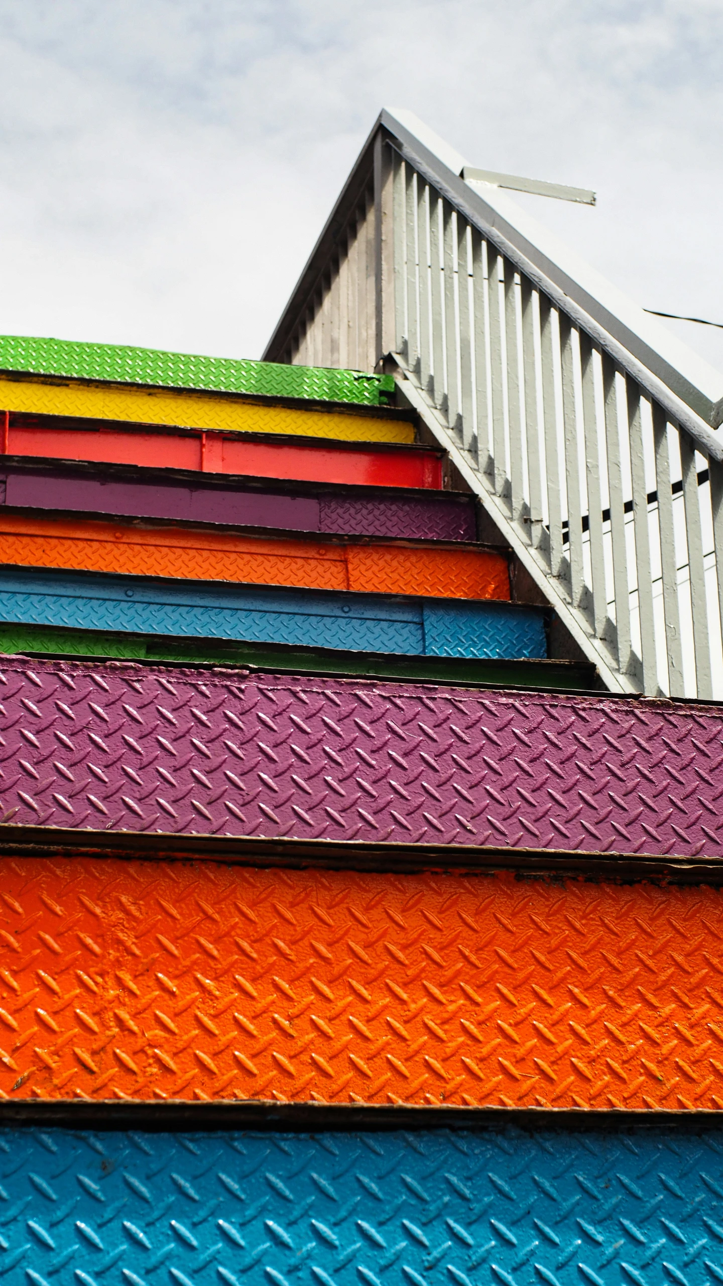 multicolored stairs, a building's roof and a traffic signal