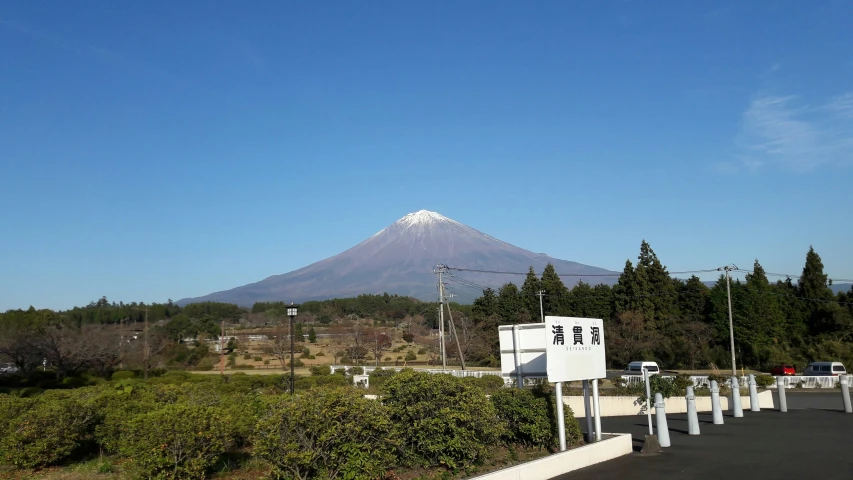 a mountain with some trees in the background and white buildings