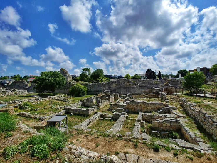 many ruins sitting in the middle of some grassy area