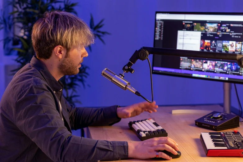 a young man recording in front of a computer screen