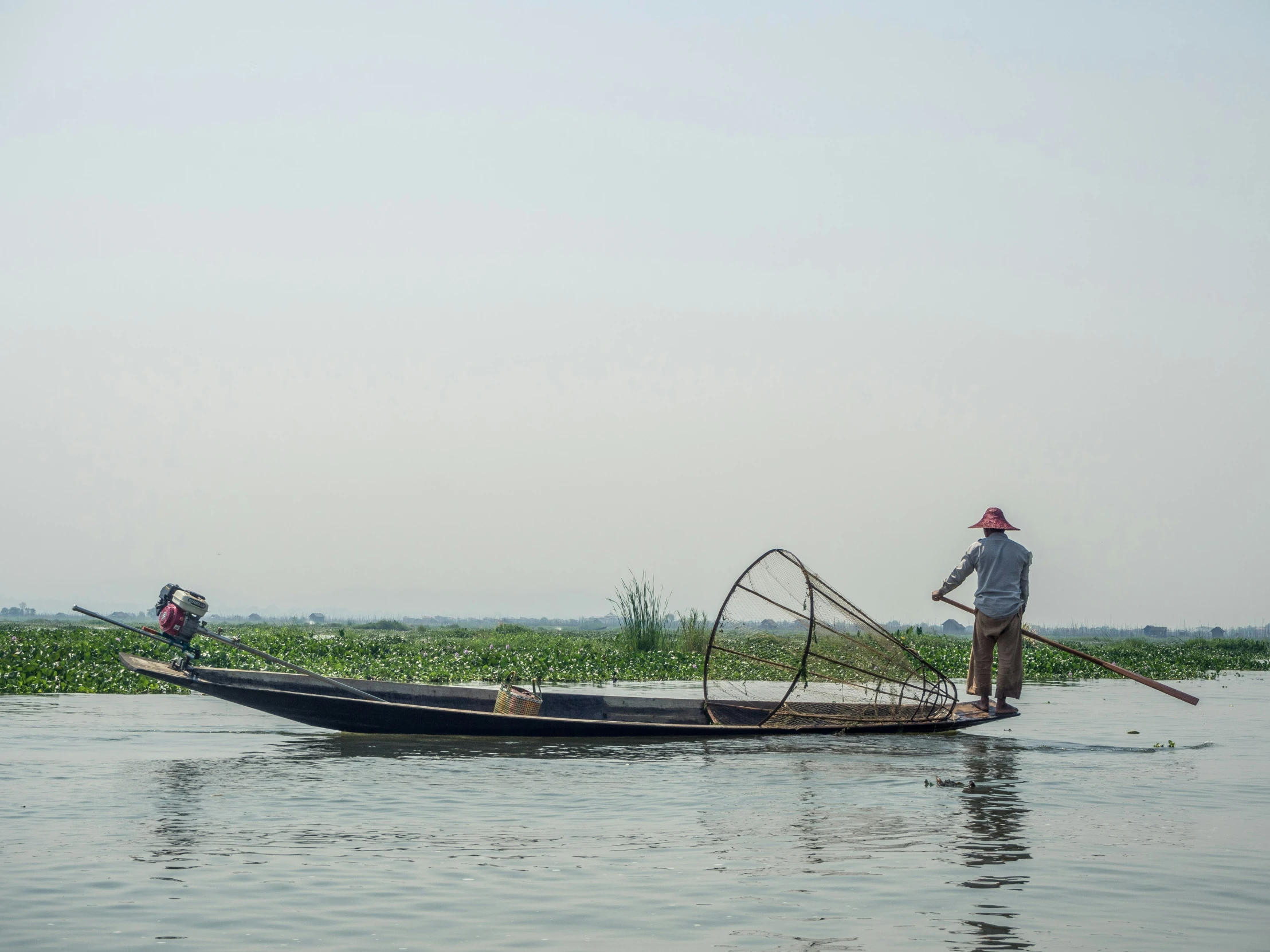 a man riding a boat while holding a fishing pole