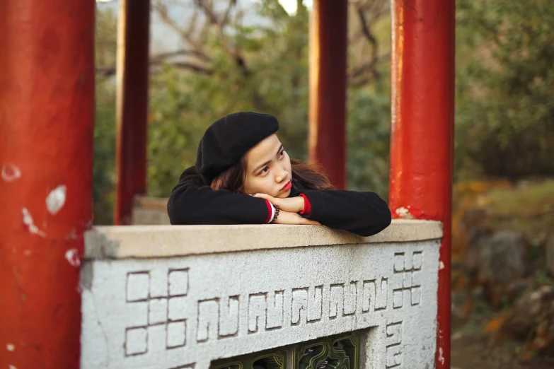 a  leans on the wall near a red torin