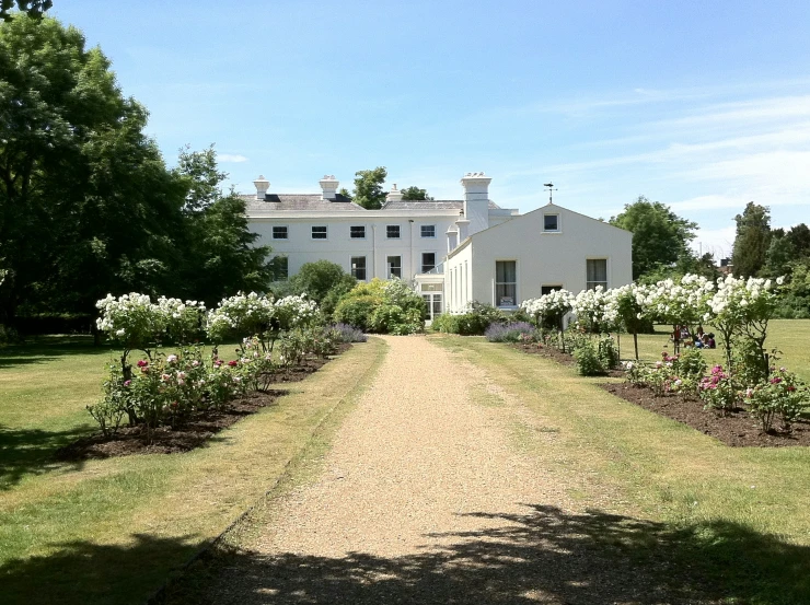 a road runs through a large mansion with tall white chimneys