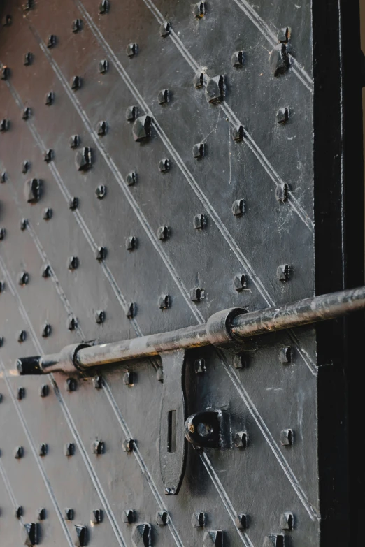 a door with multiple rivets is open and there are screws on it