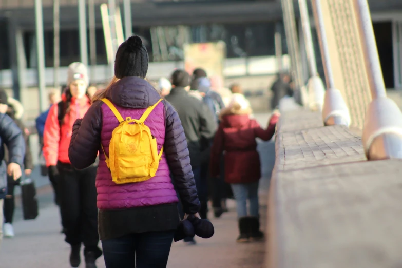 a woman walking in the middle of a line with her back pack on