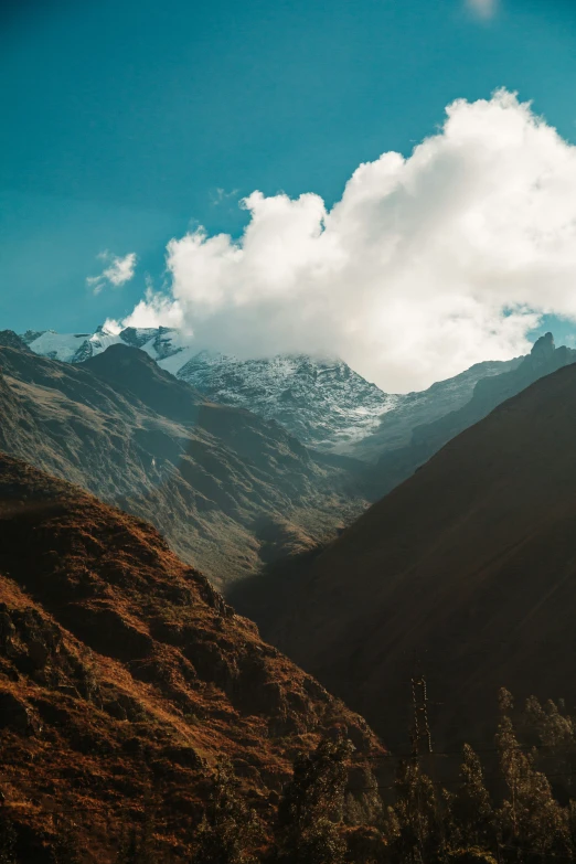 a mountain landscape with mountains and trees, with snow on the top