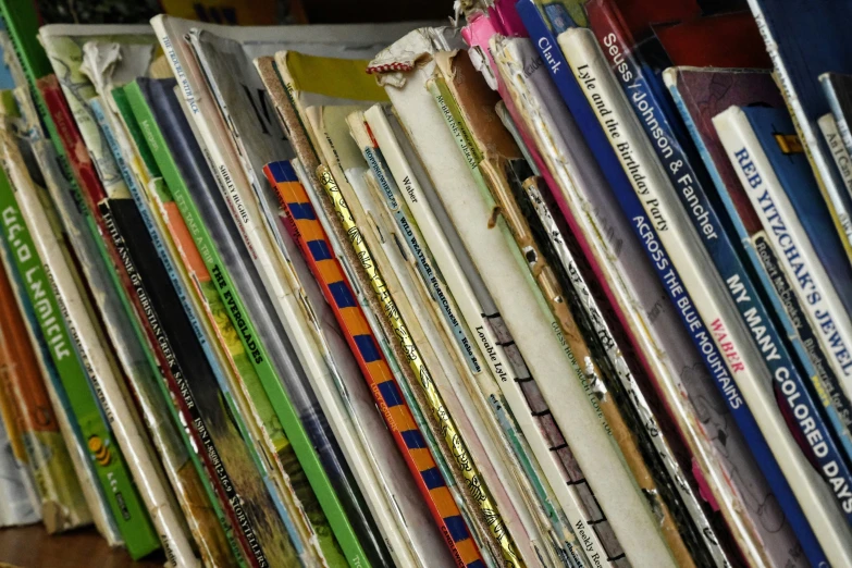 many books are stacked on each other with a clock