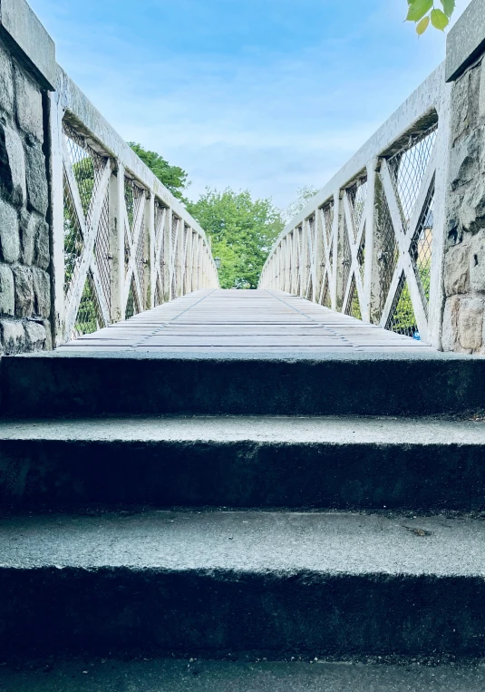 an old stone bridge with steps leading into the sky