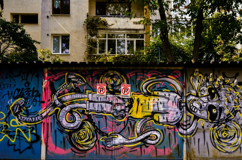 a wall covered in graffiti near a building