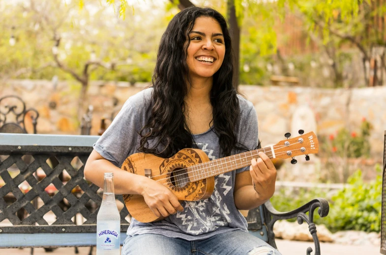 woman sitting on a park bench holding an ukulele