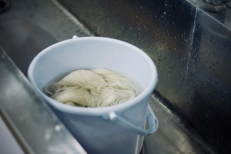 a bucket of long hair sits on a sink