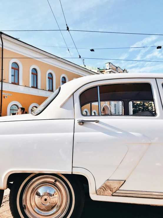 an old car parked next to a building with lots of windows