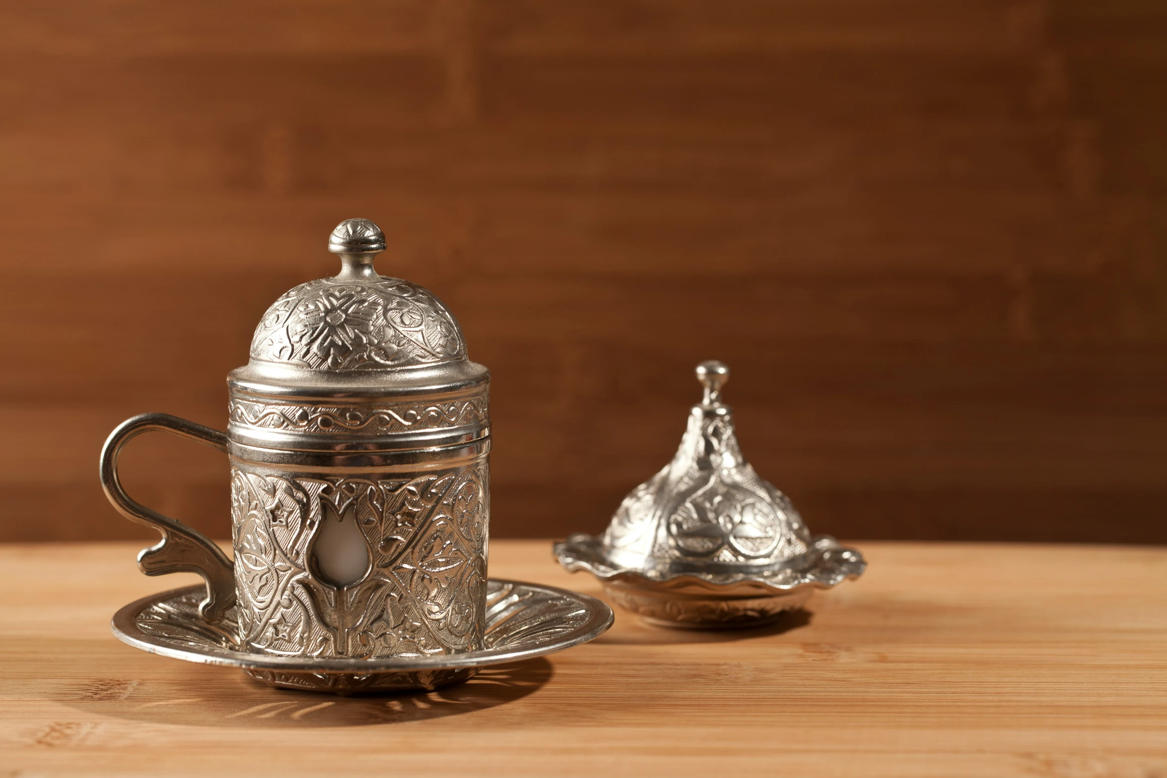 a silver tea set on top of a wooden table