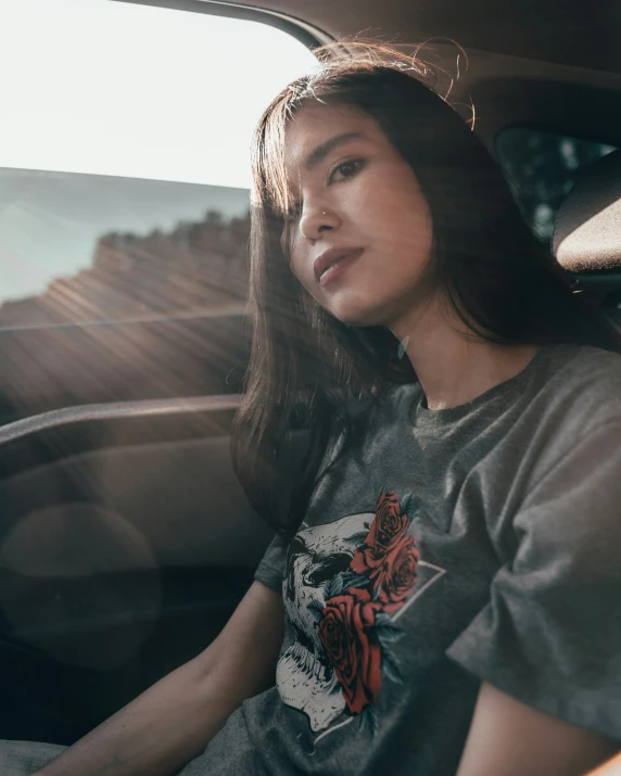 a woman sitting in the back of a car with her hand in her pocket