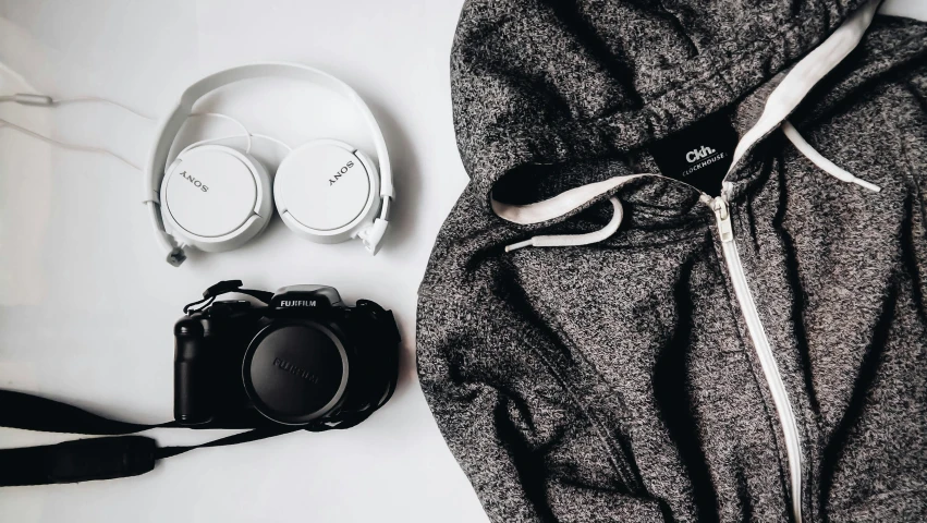 a bag, headphones, and a camera sitting on a table