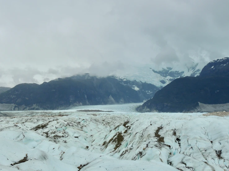 there is snow on the ground and a mountain behind