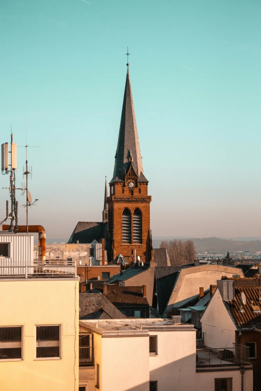 old fashioned building with a small spire with rooftops and roofs