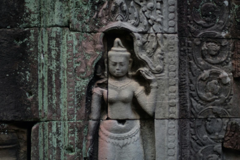 a stone figure sitting next to a wall in a stone room