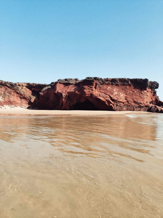 the view of an area with rocks on the beach, water, and sand