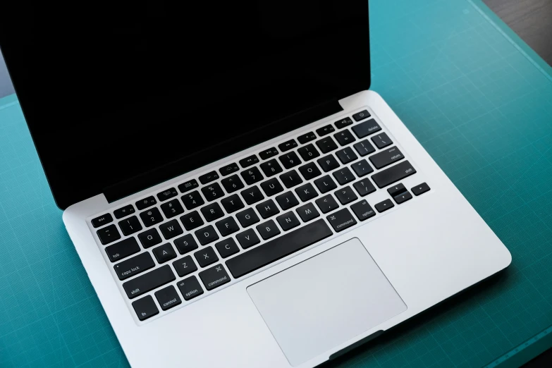 an open laptop computer sitting on top of a blue table