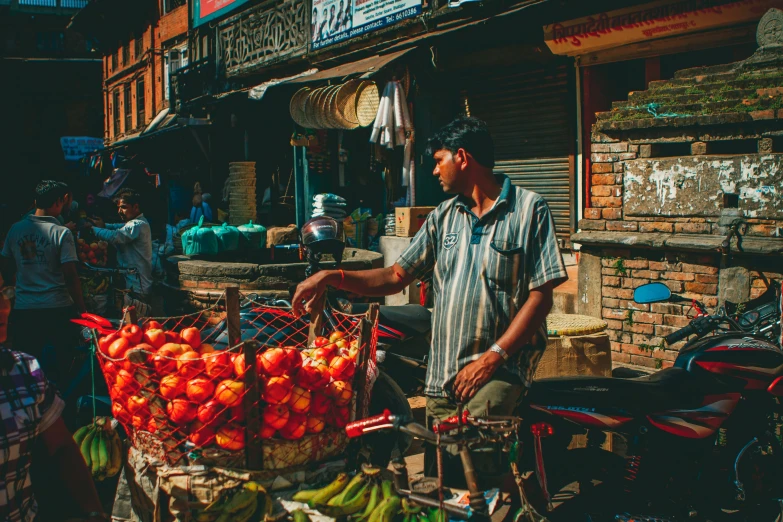 there is a man on the market holding a basket of fruits