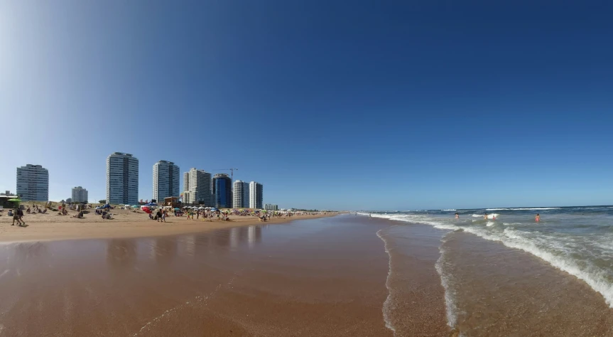 people on the beach with buildings behind them