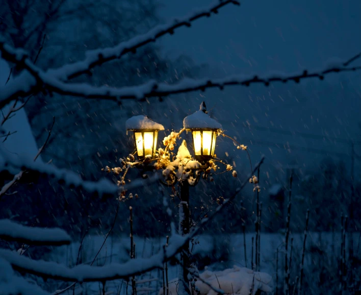 there are three light posts lit up with snow