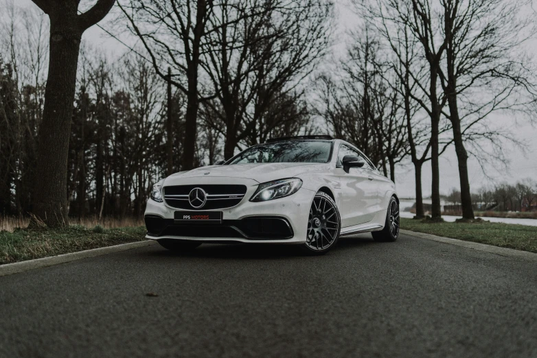 mercedes benz amg is parked in front of some trees