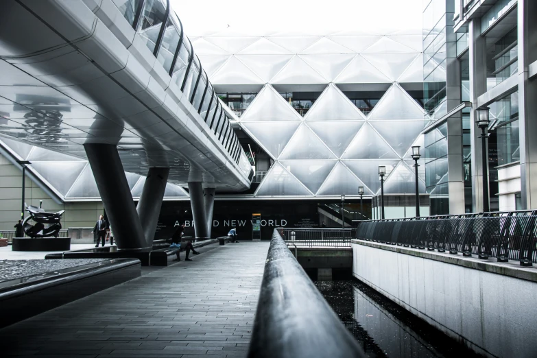 some people standing outside a building with very long walkway