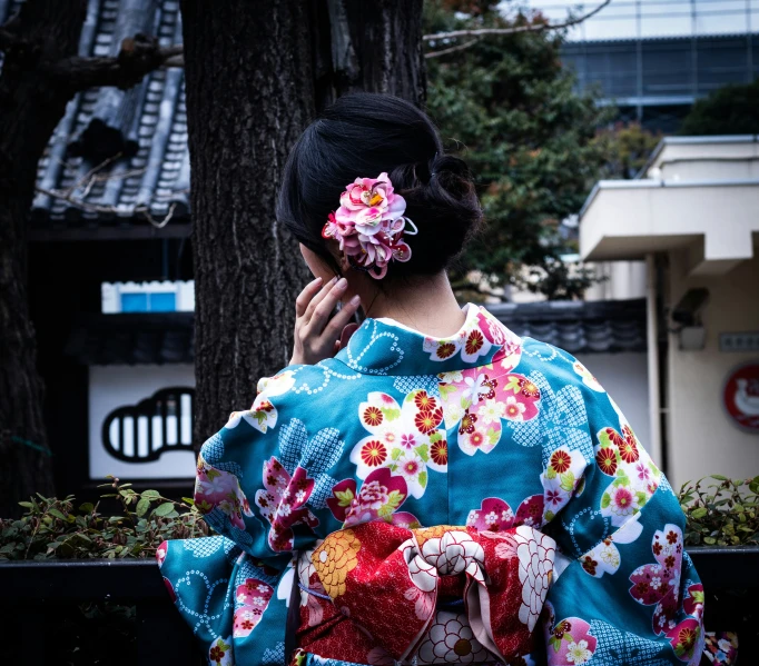 woman in blue kimono talking on cell phone