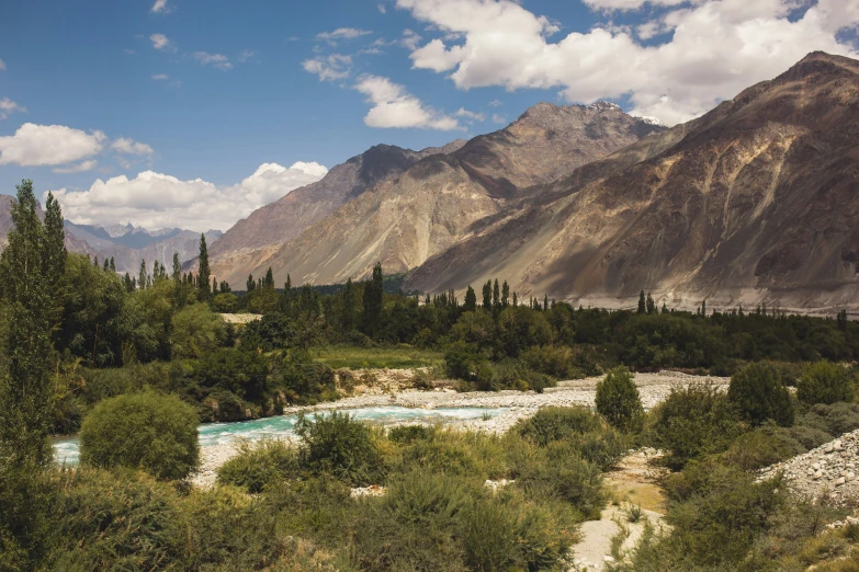 the river runs through this rocky valley near mountains