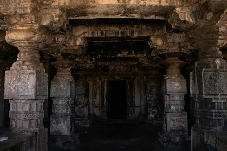 an old stone building with a couple of pillars