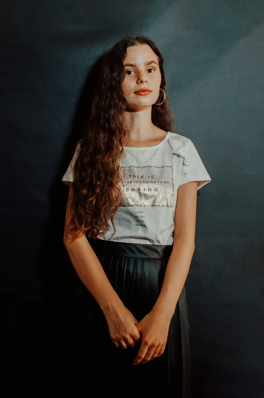 a  with her hair down wearing a white shirt and black skirt