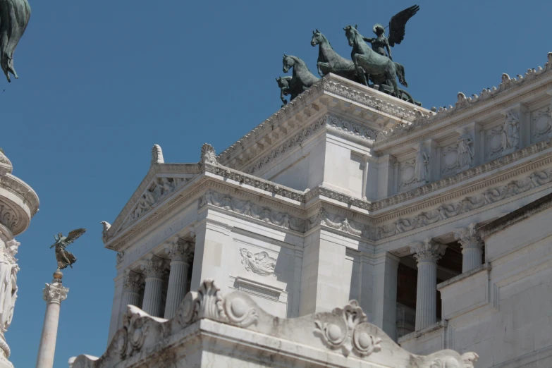 the building has statues on top and sculptures near it