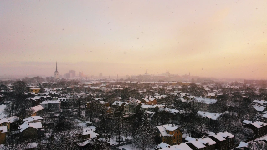 the view from the top of a building with many roofs covered in snow