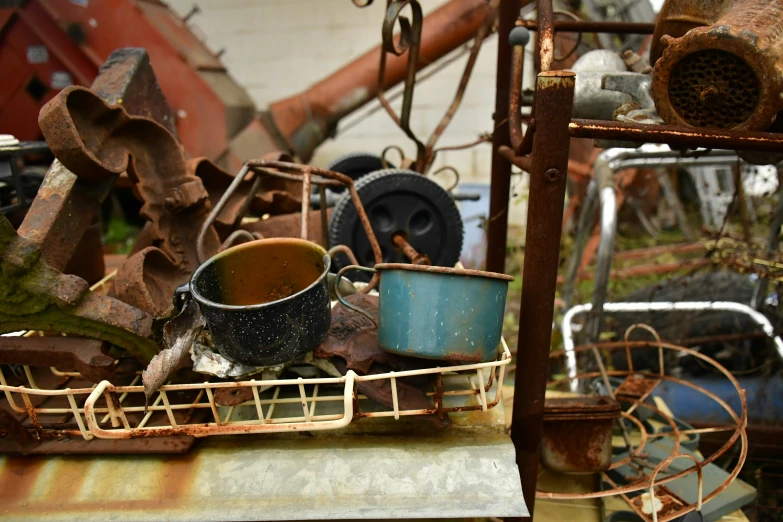 junk pile in a yard with metal pieces stacked in a basket