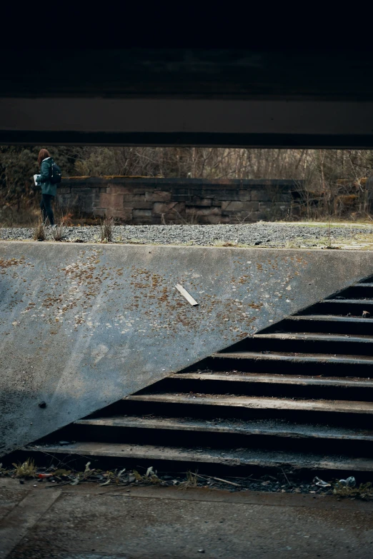 a guy walking across the rails in a dark place