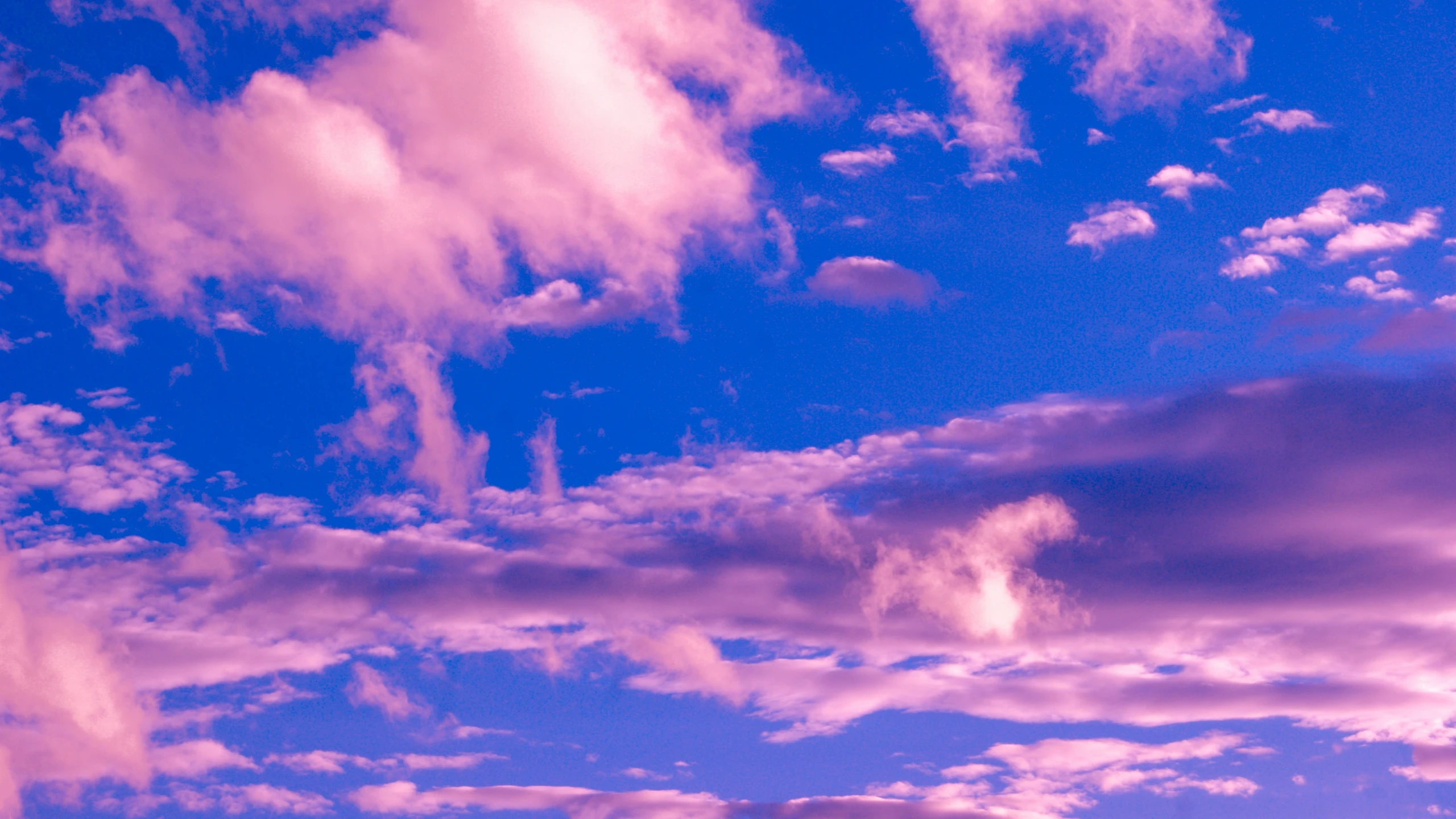 clouds in a bright blue sky, over looking a large area of land