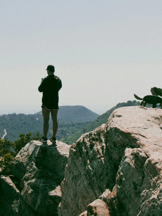 a man and his dog on top of a large mountain