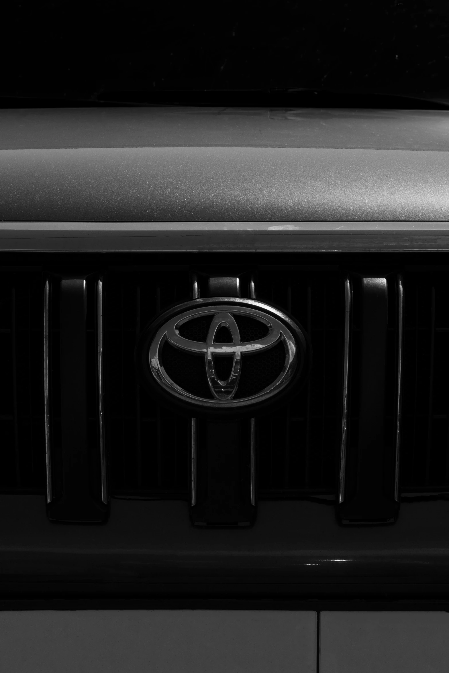 the front grille of a black car with a toyota emblem on it