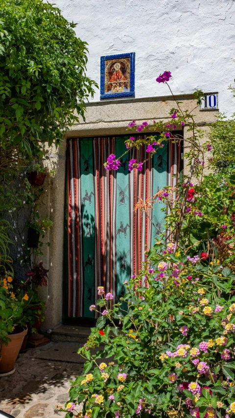 a house with a flowered garden and green door