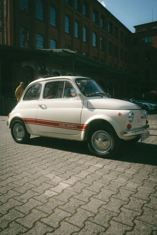 an old white car sitting on the street